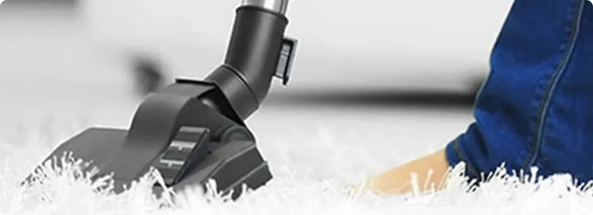 Close-up of a professional vacuuming a white carpet in Irmo.